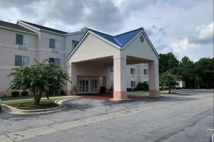 费耶特维尔Country Inn & Suites by Radisson, Fayetteville I-95, NC的蓝色屋顶的白色大建筑
