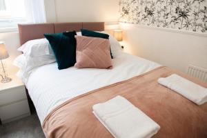 克利夫利斯Charles Alexander Short Stay - Highcliffe Apartments的一间卧室配有一张大床和两条毛巾