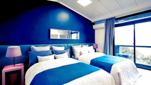 箱根gran terrace Le Lien Hakone的蓝色墙壁客房的两张床
