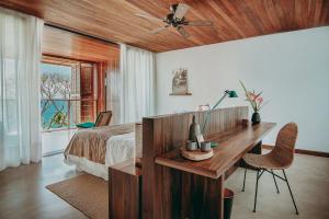 伊塔卡雷Barracuda Hotel & Villas的一间卧室配有一张床、一张书桌和一个窗户。