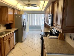 西耶斯塔岛Island House Beach Resort 16N的厨房配有木制橱柜和冰箱。