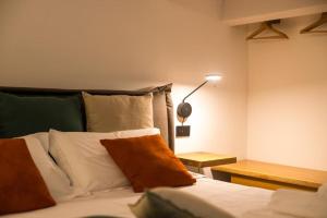 切法卢MORAMUSA Charme Apartment的一间卧室配有一张床、一盏灯和一张桌子