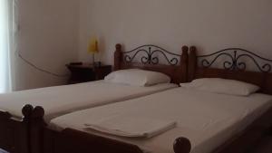 卢特拉艾季普苏Mouroukis Rooms的两张床,配有白色床单和白色毛巾
