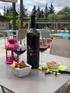 凯萨尔格Logis Hôtel Restaurant Les Aubuns的一瓶葡萄酒和一碗桌上的食物