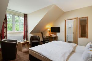 GensingenClassicX Landhaus & Hotel - Bed & Breakfast的配有一张床和一张书桌的酒店客房