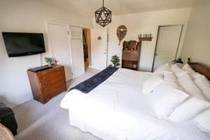班夫Banff Mountain Home- The Real Rockies Experience的卧室配有白色的床和电视。