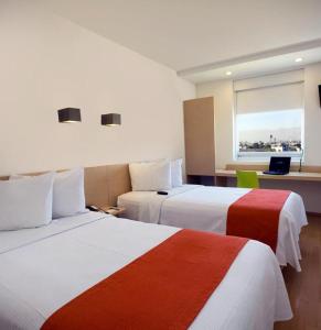 圣路易斯波托西圣路易斯波托西华雷斯格洛列塔One酒店的酒店客房设有两张床和窗户。