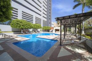 埃莫西约埃莫西美洲嘉年华酒店的一座带椅子的游泳池以及一座建筑
