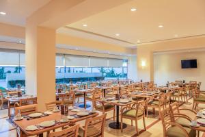 提华纳蒂华纳奥塔伊嘉年华酒店 的大型用餐室配有桌椅