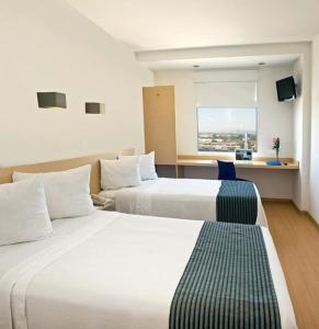 阿瓜斯卡连特斯阿瓜斯卡连特斯圣马科斯One酒店的酒店客房设有两张床和窗户。