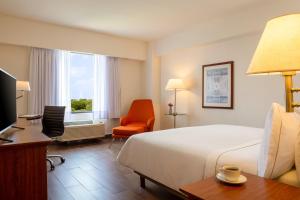 坦皮科费斯特旅馆－坦皮科的酒店客房配有一张床、一张桌子和一把椅子。