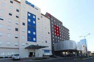 克雷塔罗One Queretaro Centro Sur的上面有红色和蓝色标志的酒店大楼