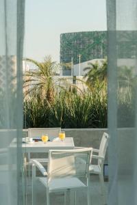 梅里达梅里达嘉年华酒店的一张白色的桌子和椅子,上面有两个橙子