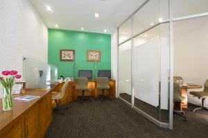 帕丘卡德索托伽玛帕丘卡酒店的办公室设有绿色的墙壁、桌子和椅子
