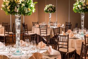 克雷塔罗盛大嘉年华美洲克雷塔罗酒店的配有桌椅和鲜花的房间