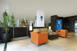 托卢卡托卢卡机场酒店的大堂设有2把橙色椅子和沙发