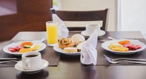坦皮科Gamma Tampico的餐桌,盘子和一杯橙汁
