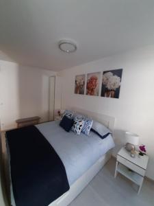 布达佩斯Rozsa 55 Appartment的白色卧室配有一张带蓝色枕头的大床