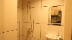 贝克西Apartemen Grand Kamala Lagoon by Cheapinn的带淋浴、盥洗盆和镜子的浴室