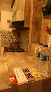 贝克西Apartemen Grand Kamala Lagoon by Cheapinn的厨房柜台,提供两瓶水和食物