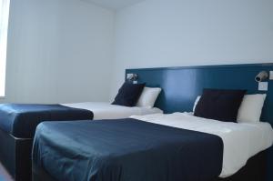 莱斯特Bell Gate House的两张位于酒店客房的床,拥有蓝色的墙壁