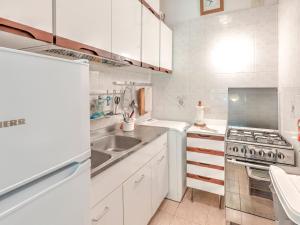 蓬塔阿拉Belvilla by OYO Le Mimose nr 11的白色的厨房设有水槽和炉灶。