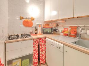 蓬塔阿拉Belvilla by OYO Le Mimose nr 12的厨房配有白色橱柜和炉灶烤箱。
