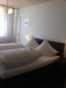 Kirchheim am Neckar乌尔曼斯霍夫旅馆的一间卧室配有两张带白色枕头的床