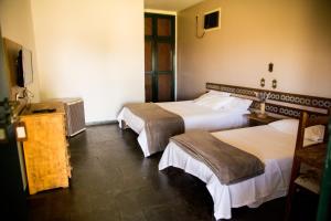 克鲁赛罗Pousada Flor da Serra的酒店客房设有两张床和电视。