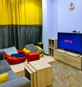 赫尔格达Marina Square Hostel的客厅配有电视、沙发和床。