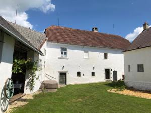 KojeticeHistoric Farmhouse Kojetice的一座白色的大建筑,前面有一个院子