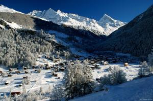 洪德莱斯维斯韦酒店的雪中的小村庄,有雪覆盖的山脉