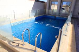图赖夫Al Chaffa Chalets的大楼内的一个蓝色海水游泳池
