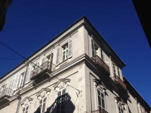 阿尔巴可卡之家公寓的一座高大的白色建筑,设有窗户,天空蔚蓝