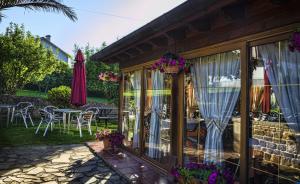 桑提亚纳德玛阿塔米拉卡米诺旅馆的房屋设有带桌子和遮阳伞的庭院