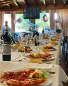 桑提亚纳德玛阿塔米拉卡米诺旅馆的长桌,带食物盘子和一瓶葡萄酒