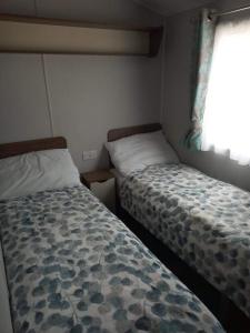 HamworthyHaven Rockley Park,Lytchett Bay View的一间卧室设有两张床和窗户。