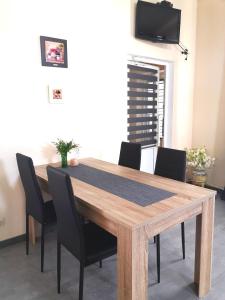 VinyntsiЗаміський будинок Fresh air的一张带黑色椅子的木桌和墙上的电视