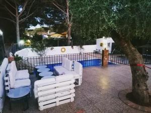 巴尔巴特芬卡埃尔阿布埃罗酒店的一组坐在树旁的白色椅子