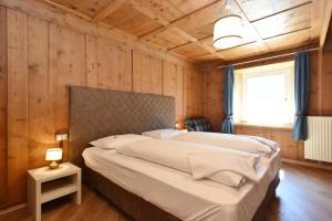 博萨迪法萨Casa Dorich的卧室配有一张木墙内的大床