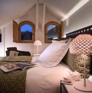安锡阿纳西维埃耶威乐旅馆的一间卧室配有一张带书籍和灯的床