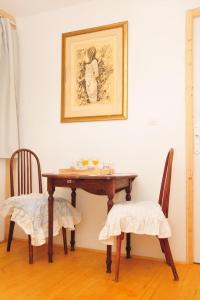 圣马丹德卡拉尔le relais des fees的一张餐桌,配有两把椅子和一张墙上的照片