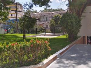 萨尔瓦多Barra Summer flat的一座种满鲜花和树木的公园和一座建筑