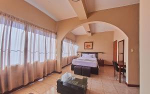 普卡尔帕Hotel America Pucallpa的酒店客房配有一张床铺和一张桌子。