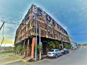 怡保M Boutique Hotel Station 18 - Ipoh的一座大型建筑,前面有汽车停放