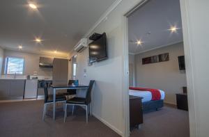 斯特拉特福德爱德苑汽车旅馆的配有一张床和一张桌子及椅子的房间