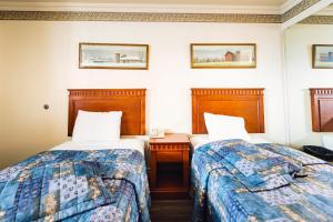 圣让上黎塞留Auberge Harris的酒店客房,设有两张床、床头柜和两张床