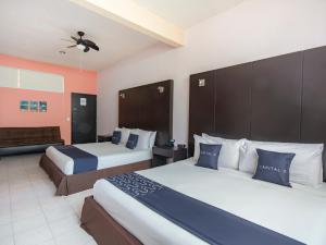 科阿特佩克Hotel Spa Shalam的酒店客房,设有两张床和一张沙发