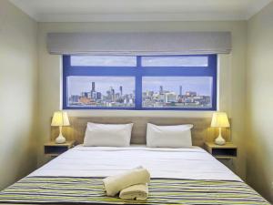 布里斯班The Windsor Hotel Rooms and Apartments, Brisbane的一间卧室设有一张大床和一个窗户。