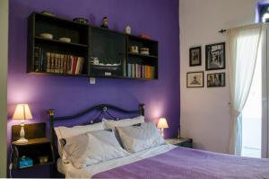 SteníBalcony to the Aegean的紫色卧室,配有一张床和一个书架